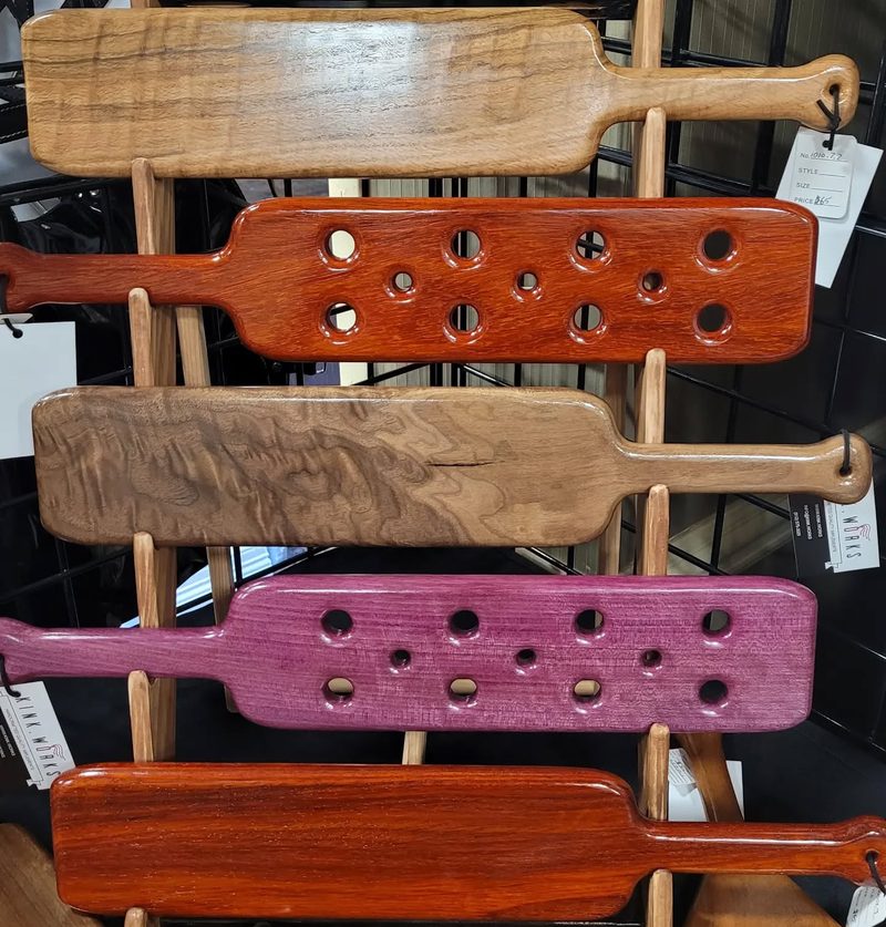 Rack of handcrafted wooden paddles in several hardwoods
